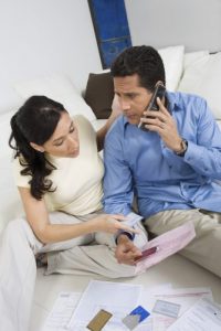 Couple With Credit Cards And Bills On Call