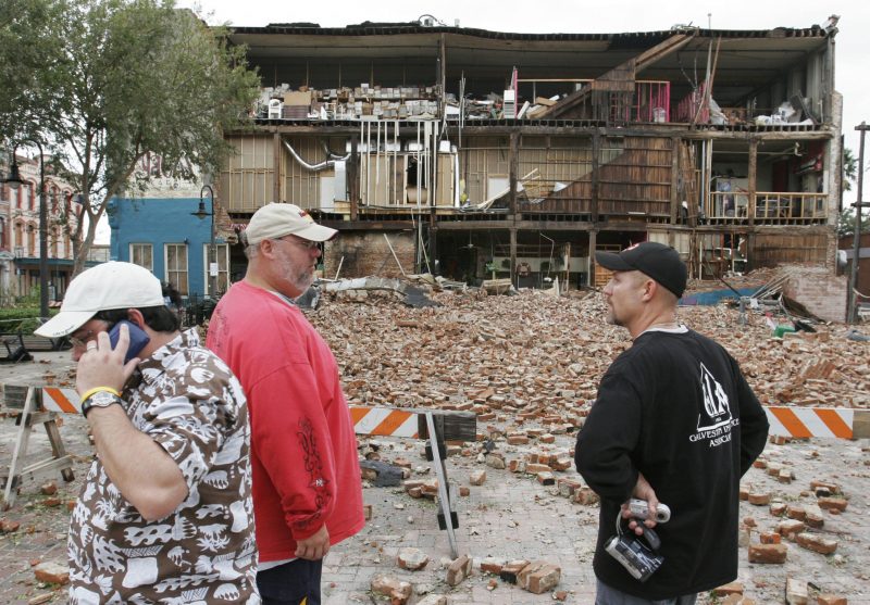 men standing in front of a damaged building in Nepal